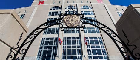 A building with a large arched entrance, a prominent 'N' logo, and a quote on the lower part of the entrance.