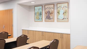 A conference room with a wooden table, chairs, and a whiteboard.