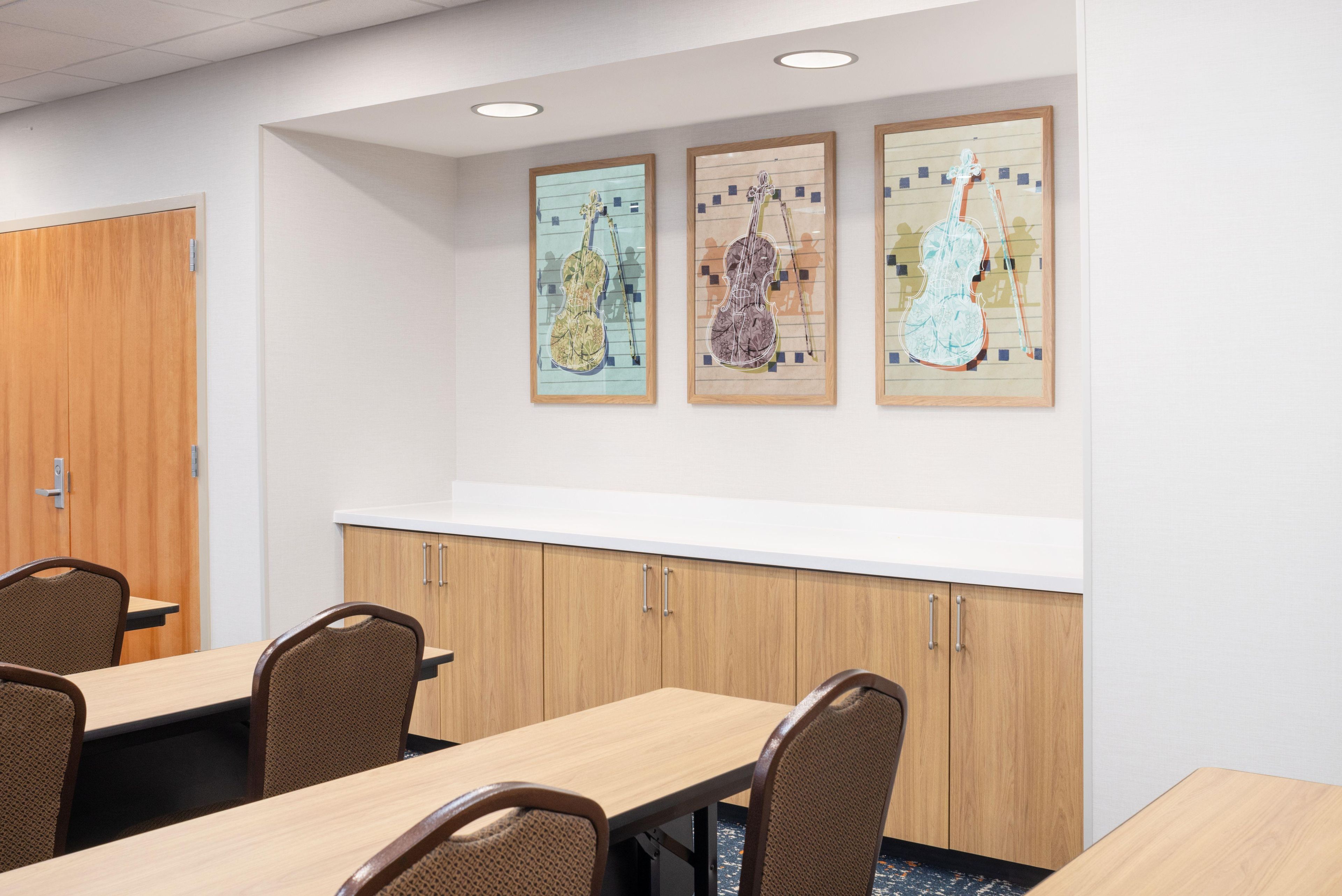 A conference room with a wooden table, chairs, and a whiteboard.