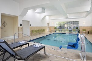 Una piscina techada, sillones reclinables de piscina