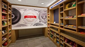 A snack display area with shelves stocked with various snacks and a large wall advertisement for treats.