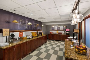 A breakfast bar with a checkered floor, wooden cabinets, and a variety of breakfast items.