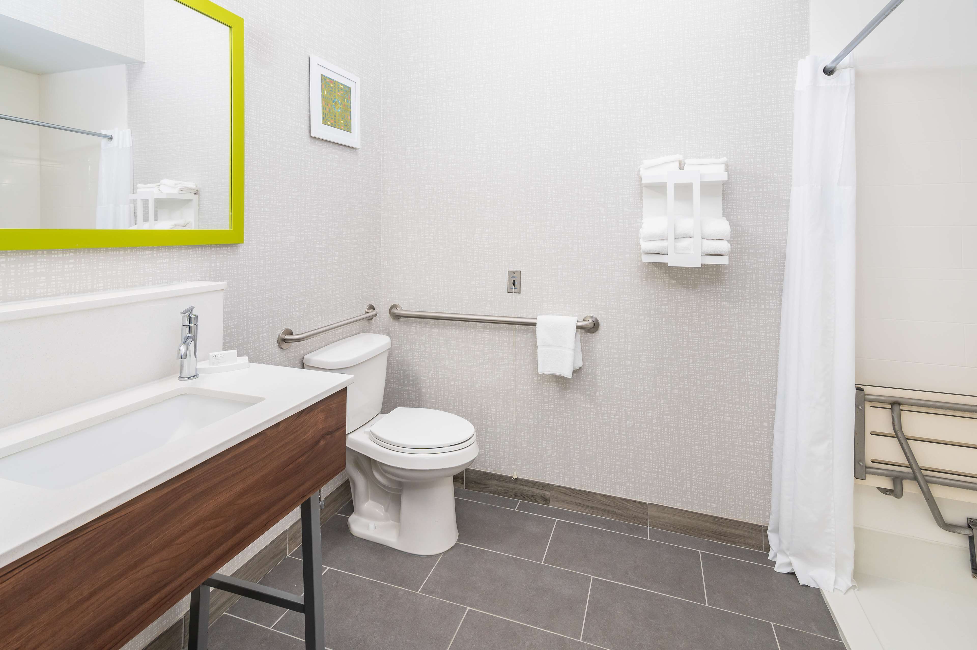 Ein Badezimmer mit weißem Waschbecken, Toilette und Duschbereich.