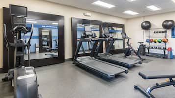 A gym with treadmills, a stationary bike, and a rowing machine.
