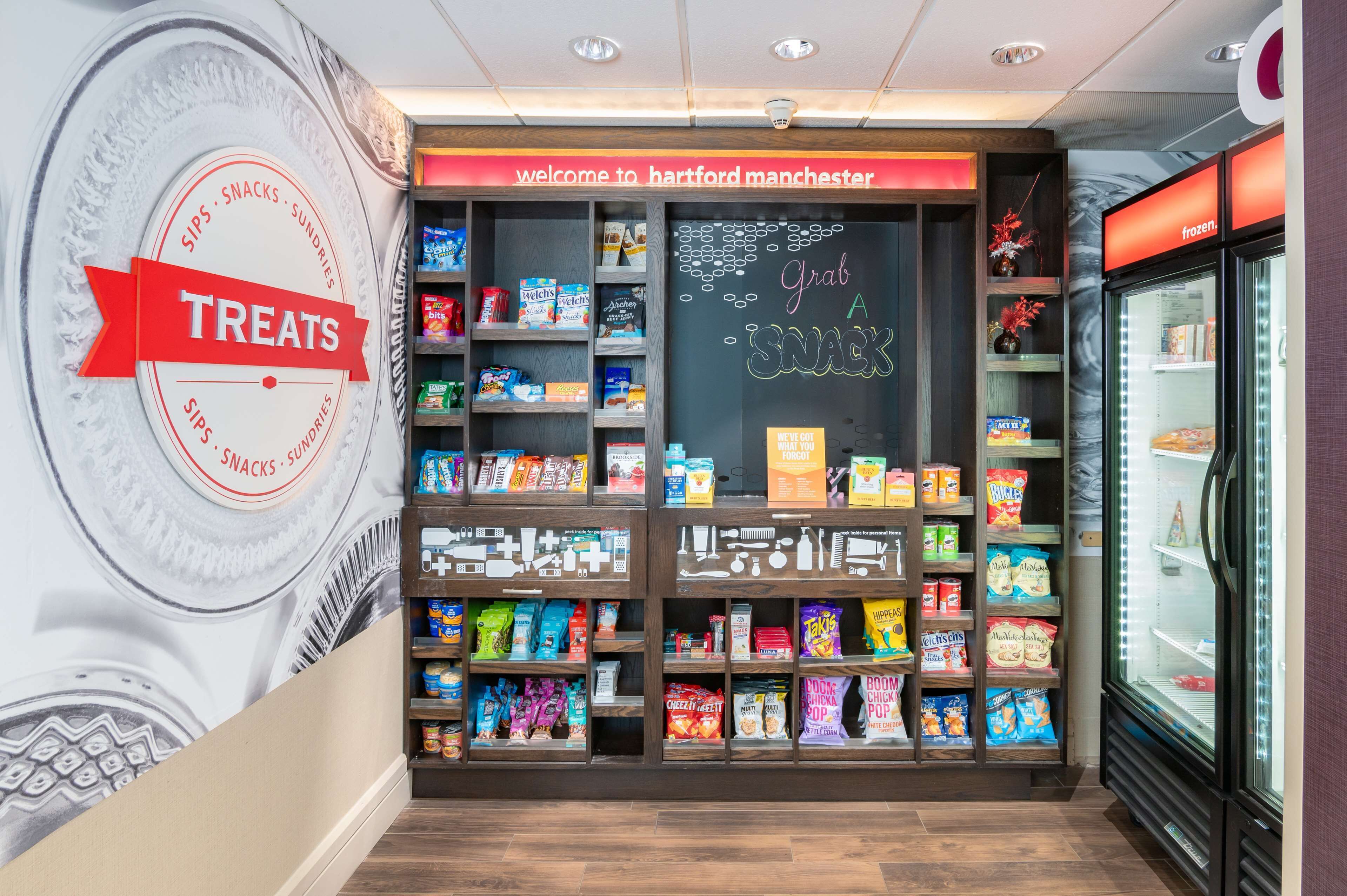 A snack section with a variety of packaged snacks and a chalkboard sign that says "Grab a snack".