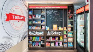 A snack section with a variety of packaged snacks and a chalkboard sign that says "Grab a snack".