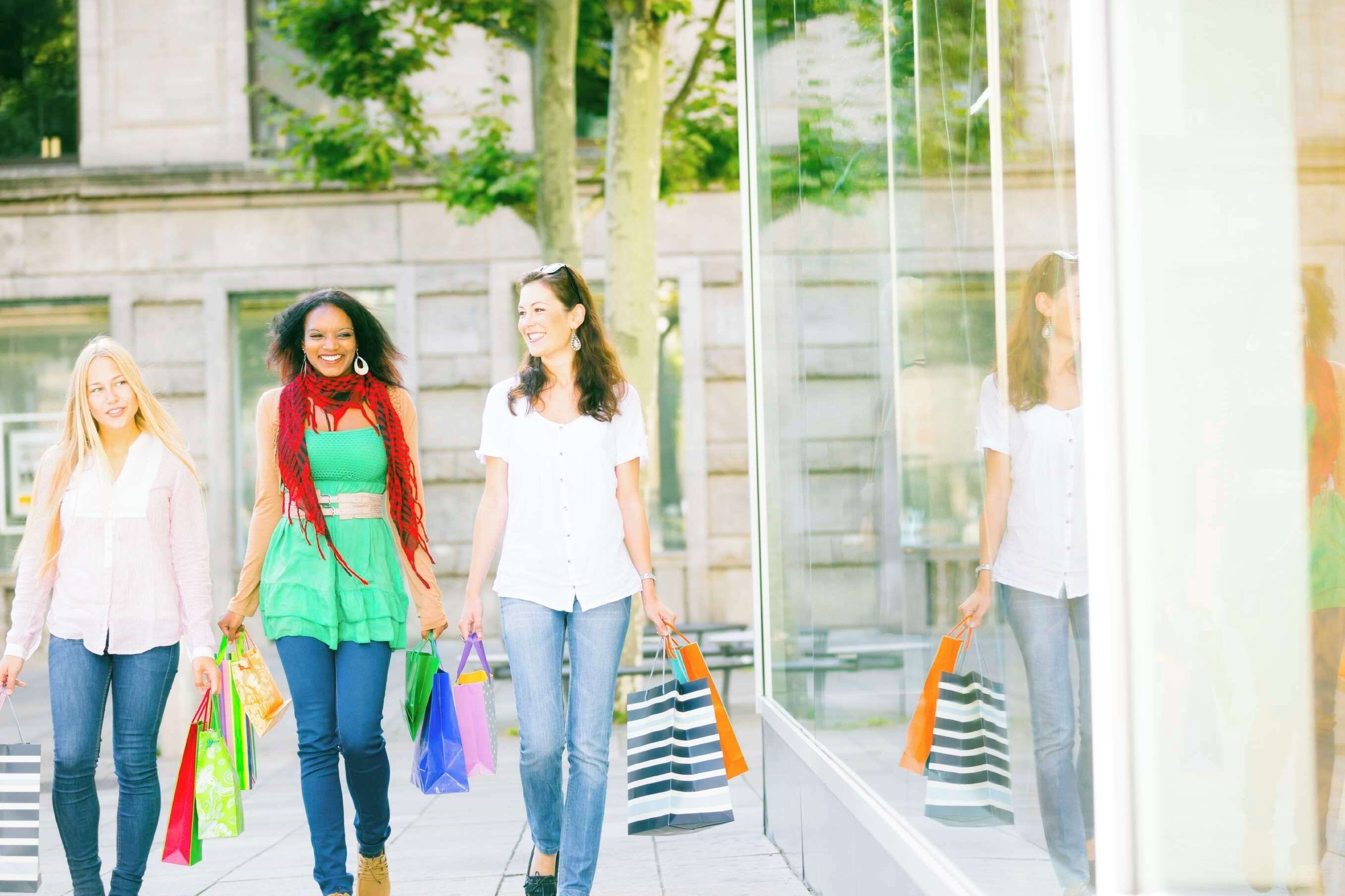 A group of people walking on a sidewalk.