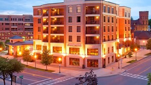 A multi-story hotel with a brick facade, multiple balconies, and a sign for Hampton Inn & Suites.