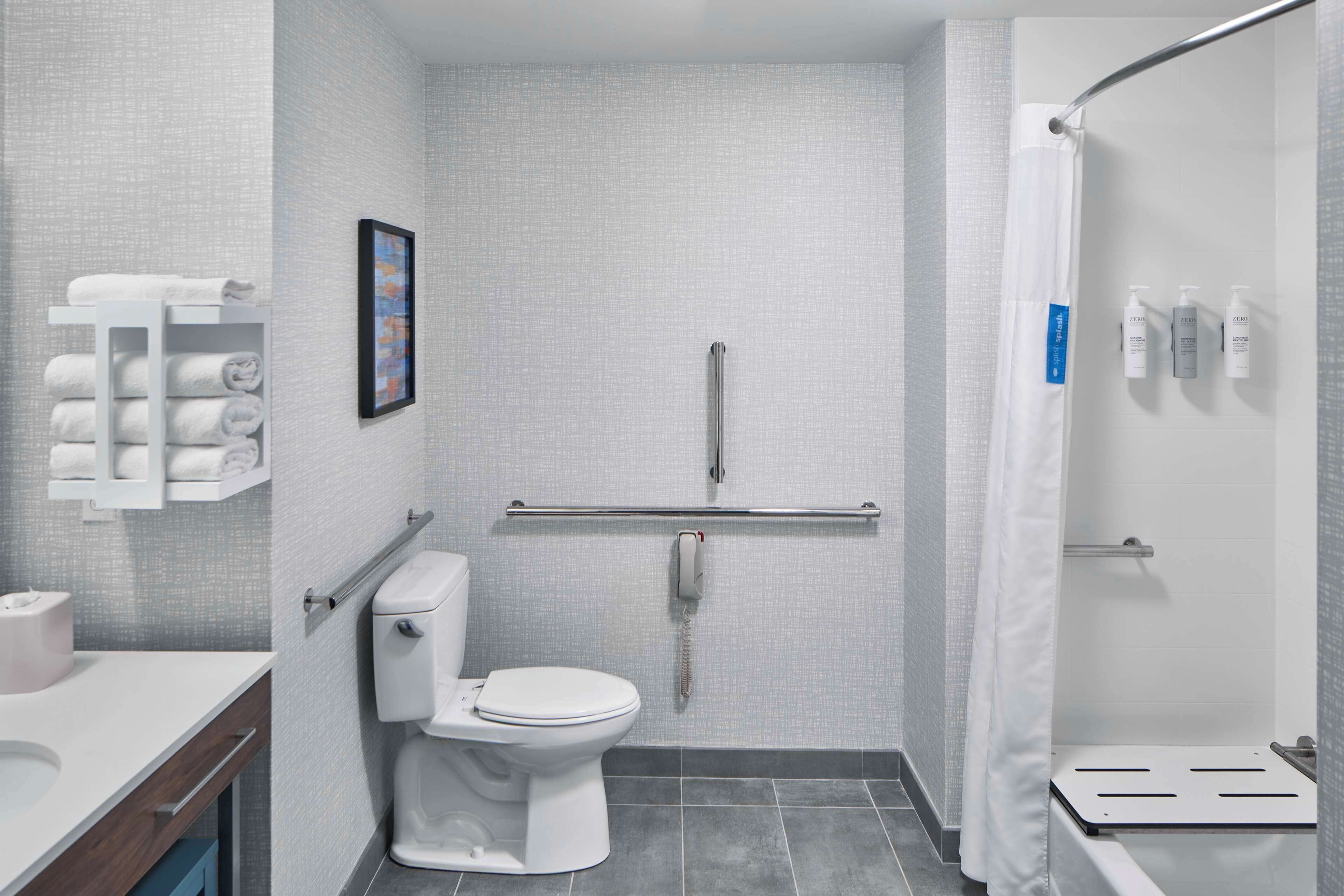Ein modernes Badezimmer mit Toilette, Waschbecken und Duschbereich.