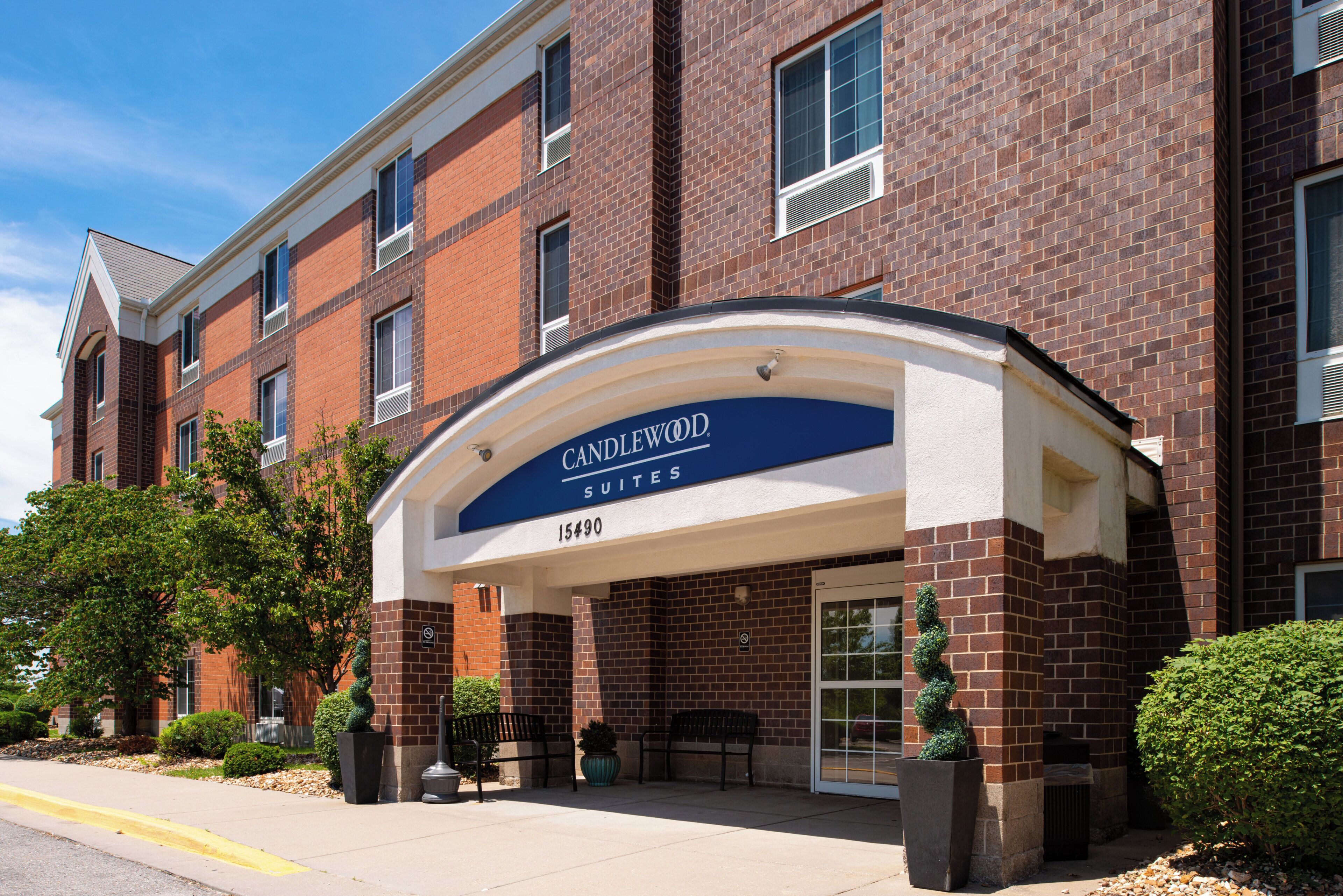 A brick building with a sign reading 'Candlewood Suites 15490.'