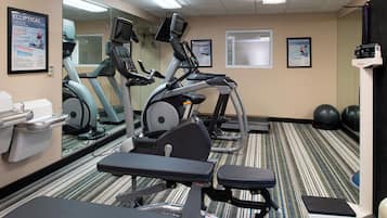 A fitness room with exercise bikes, treadmills, and a weight bench.