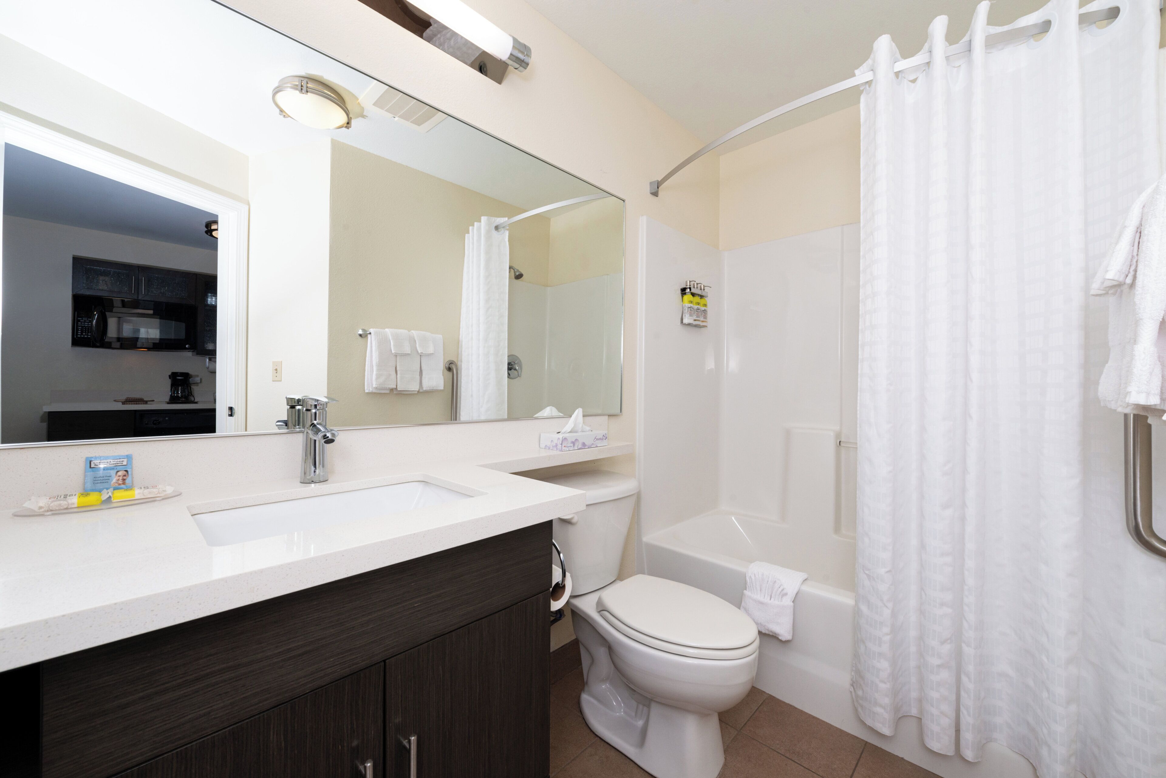 Un baño con tocador doble, inodoro, bañera y cortina de ducha.