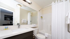 Een moderne badkamer met een wastafel met dubbele wastafel, een toilet, een bad en een douchegordijn.