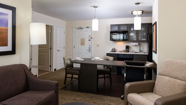 Een hotelkamer met een eethoek, kitchenette en zithoek.