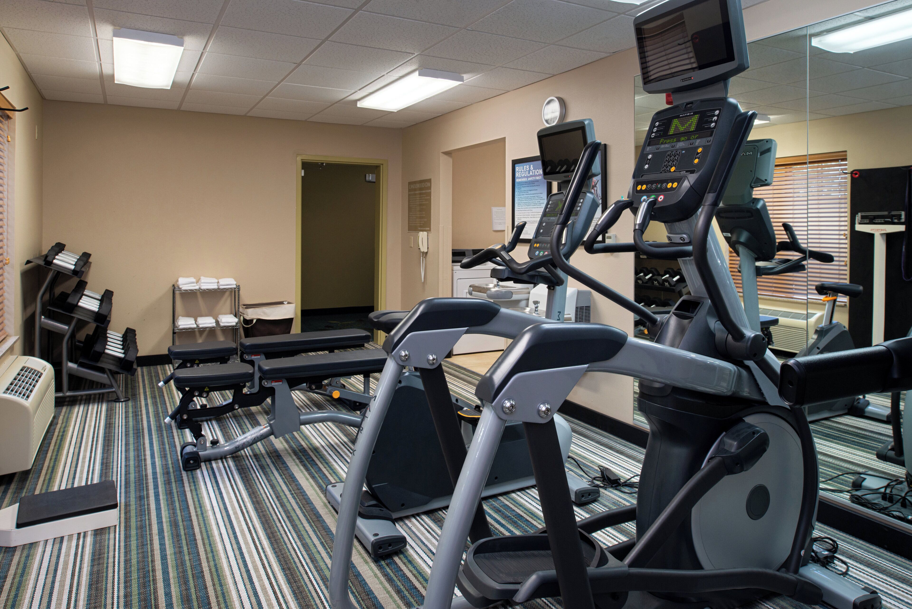 Un centre de remise en forme équipé de tapis de course, d’un appareil d’aviron et d’une zone dédiée aux exercices de développé couché.