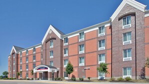 Un hôtel à plusieurs étages, doté d’une façade en briques, de grandes fenêtres et d’une entrée imposante avec une enseigne.