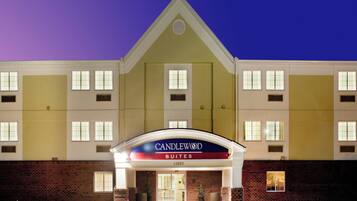 A hotel entrance with a sign reading 'CANDLEWOOD SUITES' and the number '15820' above the door.