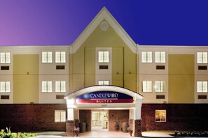 Entrada de un hotel con un letrero que dice 'CANDLEWOOD SUITES' y el número '15820' sobre la puerta.