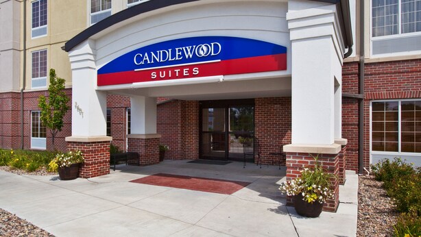 Entrada de un hotel con un cartel que dice "CANDLEWOOD SUITES".
