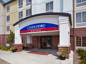 Entrada de un hotel con un cartel que dice "CANDLEWOOD SUITES".