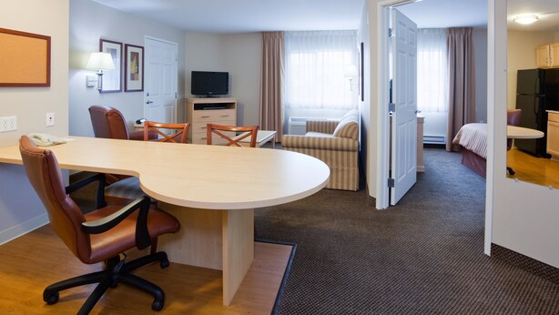 A hotel room with a dining area, a TV, a bed, and a kitchenette. - Candlewood Suites Milwaukee Brown Deer by IHG (Milwaukee)