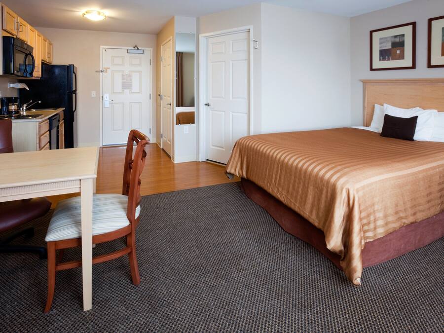 Une chambre d’hôtel équipée d’un lit, d’un bureau avec une chaise, d’un four à micro-ondes et d’un réfrigérateur.