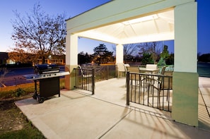 An outdoor patio area with a grill, seating, and a covered section. - Candlewood Suites Milwaukee Brown Deer by IHG (Milwaukee)