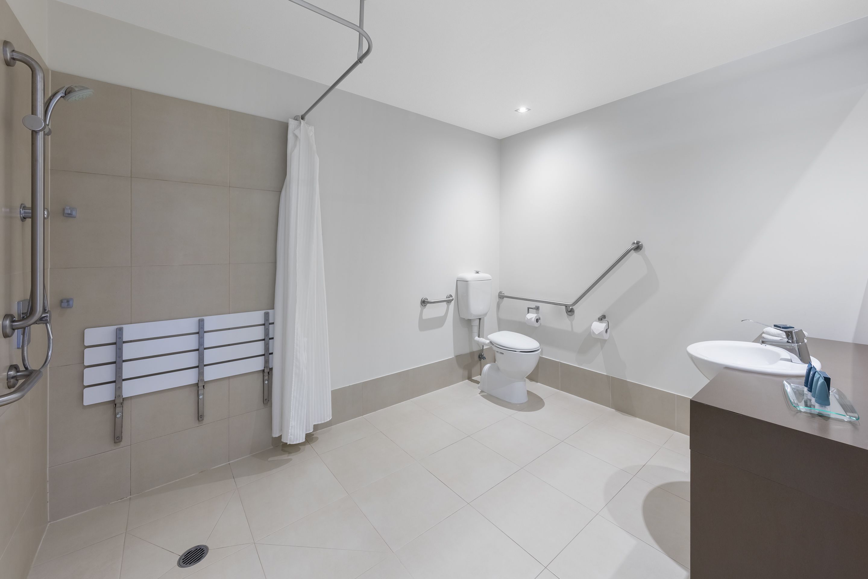 Une salle de bain moderne équipée d’une douche, de toilettes et d’un lavabo.