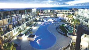 Een modern hotel met een centraal gelegen zwembad, buiten zitplaatsen en uitzicht op de oceaan.