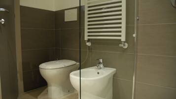 A bathroom with a toilet, bidet, and sink.