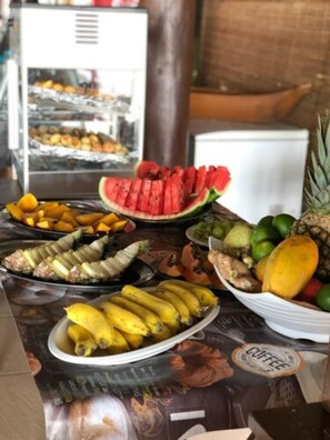 A buffet table with various fruits and a coffee machine. - Arraial Praia Hotel Pousada (Porto Seguro)