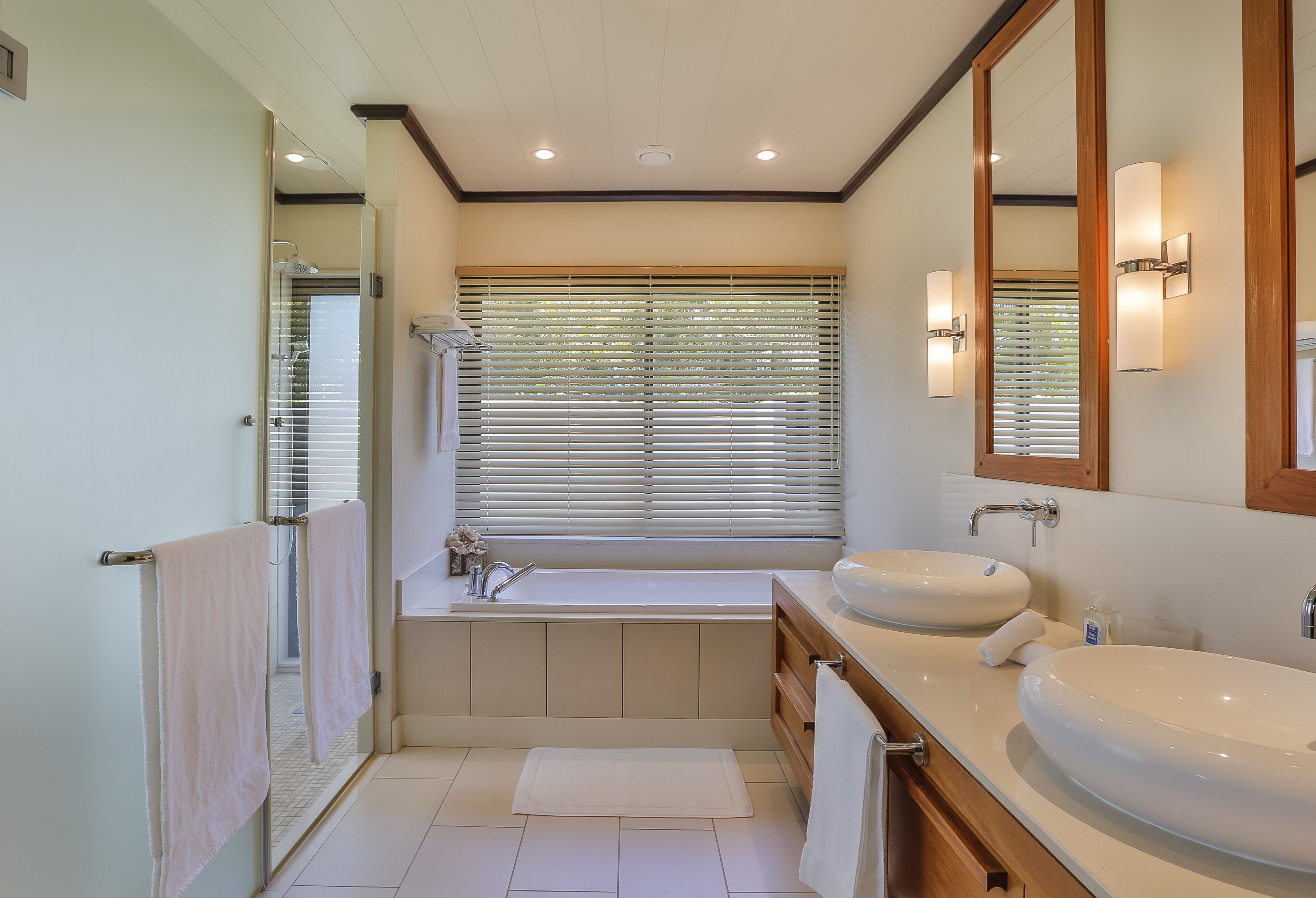 Une salle de bain moderne avec une baignoire, deux lavabos et un grand miroir.