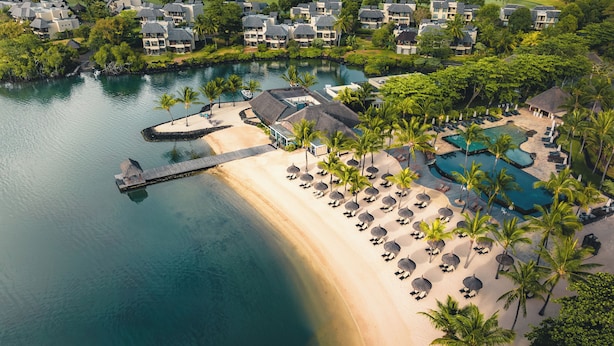 An aerial view of a resort with beachfront villas, a swimming pool, and a dock. - The Bay Club at Anahita (Grand River South East)