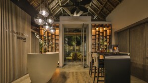 A modern interior with a reception desk, wooden flooring, and a ceiling with exposed beams. - The Bay Club at Anahita (Grand River South East)