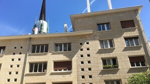 A multi-story building with a prominent spire and several chimneys. - Hôtel Vieille Tour Centre Rouen (Rouen)