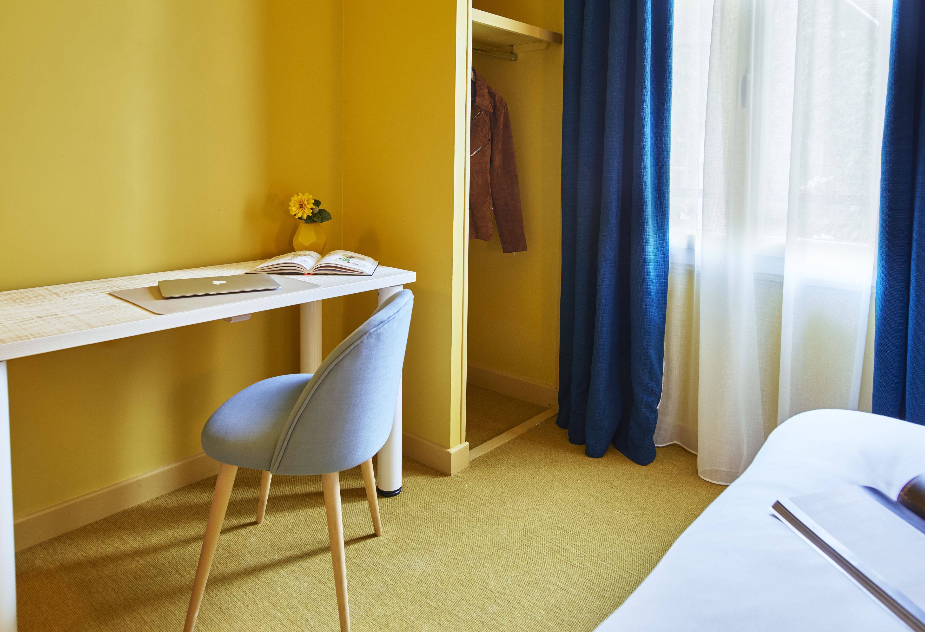 Una habitación de hotel con escritorio, silla y cama.