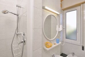 Een douche, een haardroger, een bidet, handdoeken