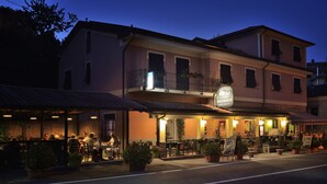 A restaurant with outdoor seating, a signboard, and potted plants. - Antica Locanda Luigina (Carrodano)