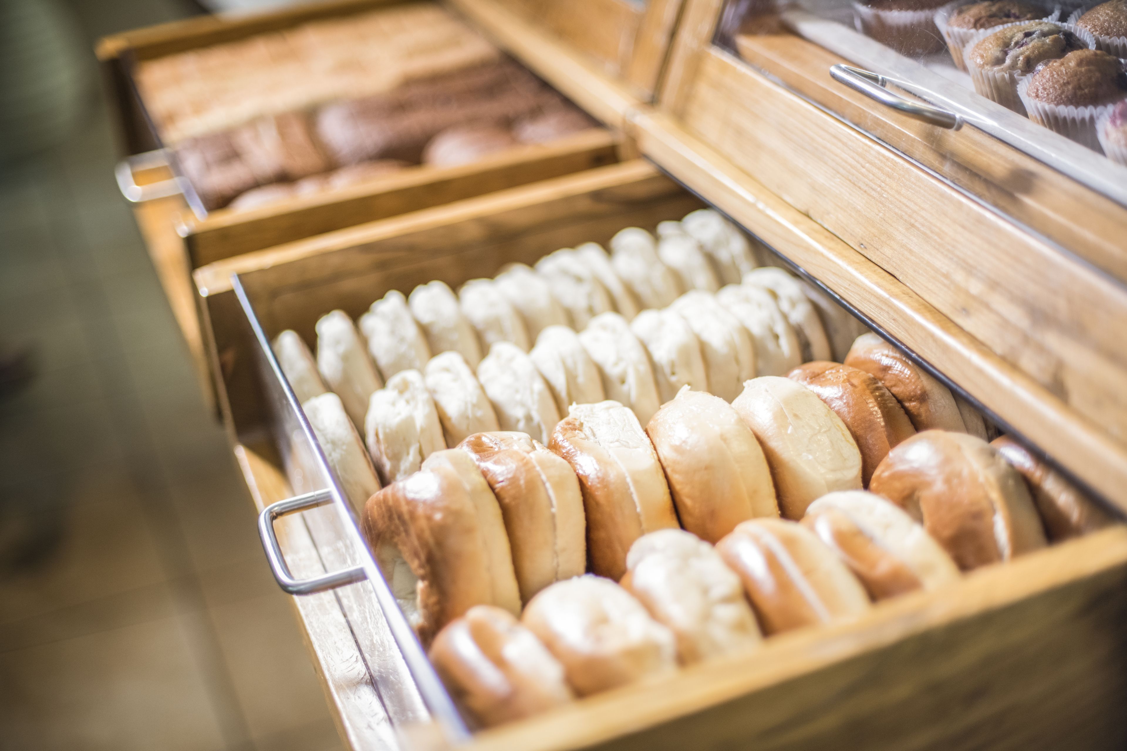 A bakery display case with various types of bread and pastries.