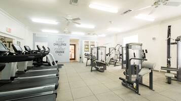 A gym with treadmills, weight machines, and a motivational quote on the wall.