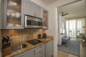 A modern kitchen with a built-in microwave, a sink, and a knife block.