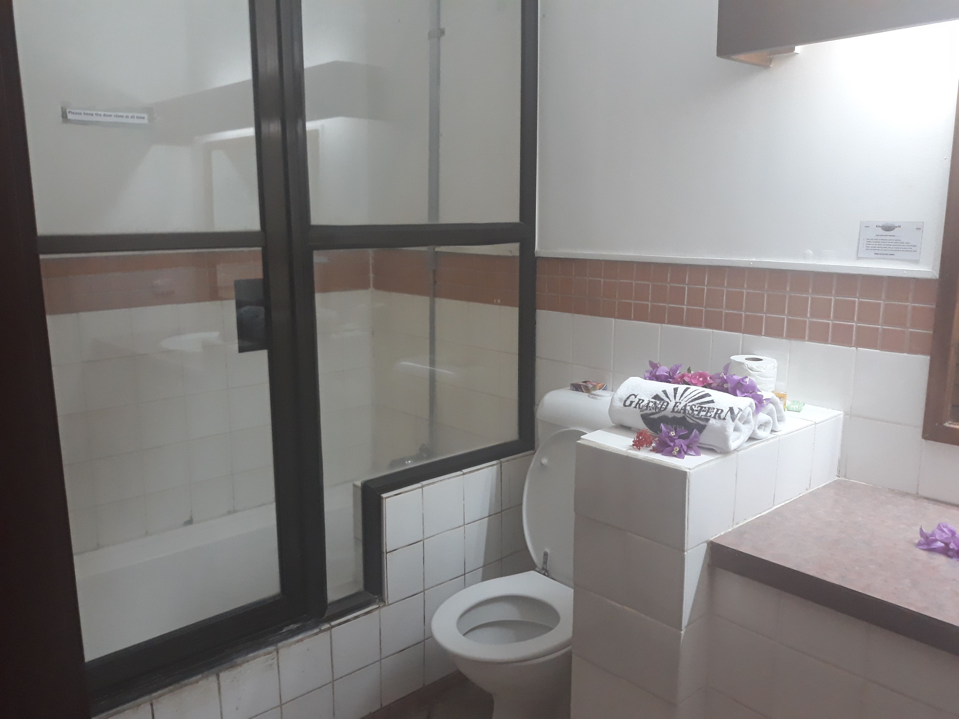 Une salle de bain comprenant des toilettes, un espace douche et un lavabo.