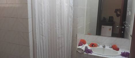 A bathroom with a white sink, mirror, and tiled walls.
