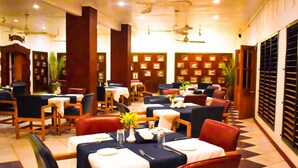 Un restaurante con mesas dispuestas para comer, sillas y ventiladores de techo.