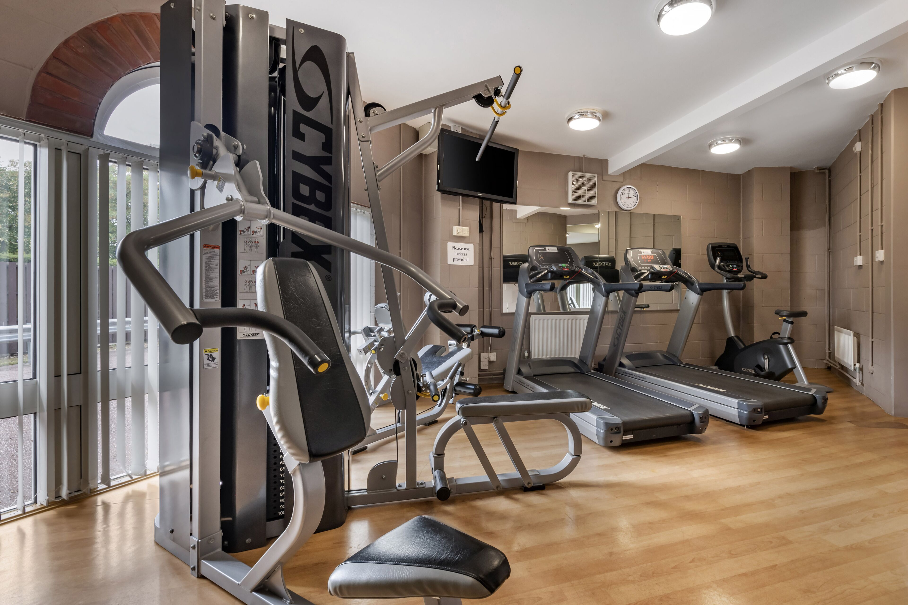 Ett gym med konditionsmaskiner, styrketräningsmaskiner och ett löpband.