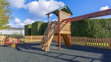 Explore the fun of a central tower with a ladder and slide in a secure playground setting.