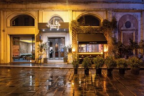 A historic building with a prominent entrance, potted plants, and a well-lit interior. - Pera Tulip Hotel & SPA (Istanbul)