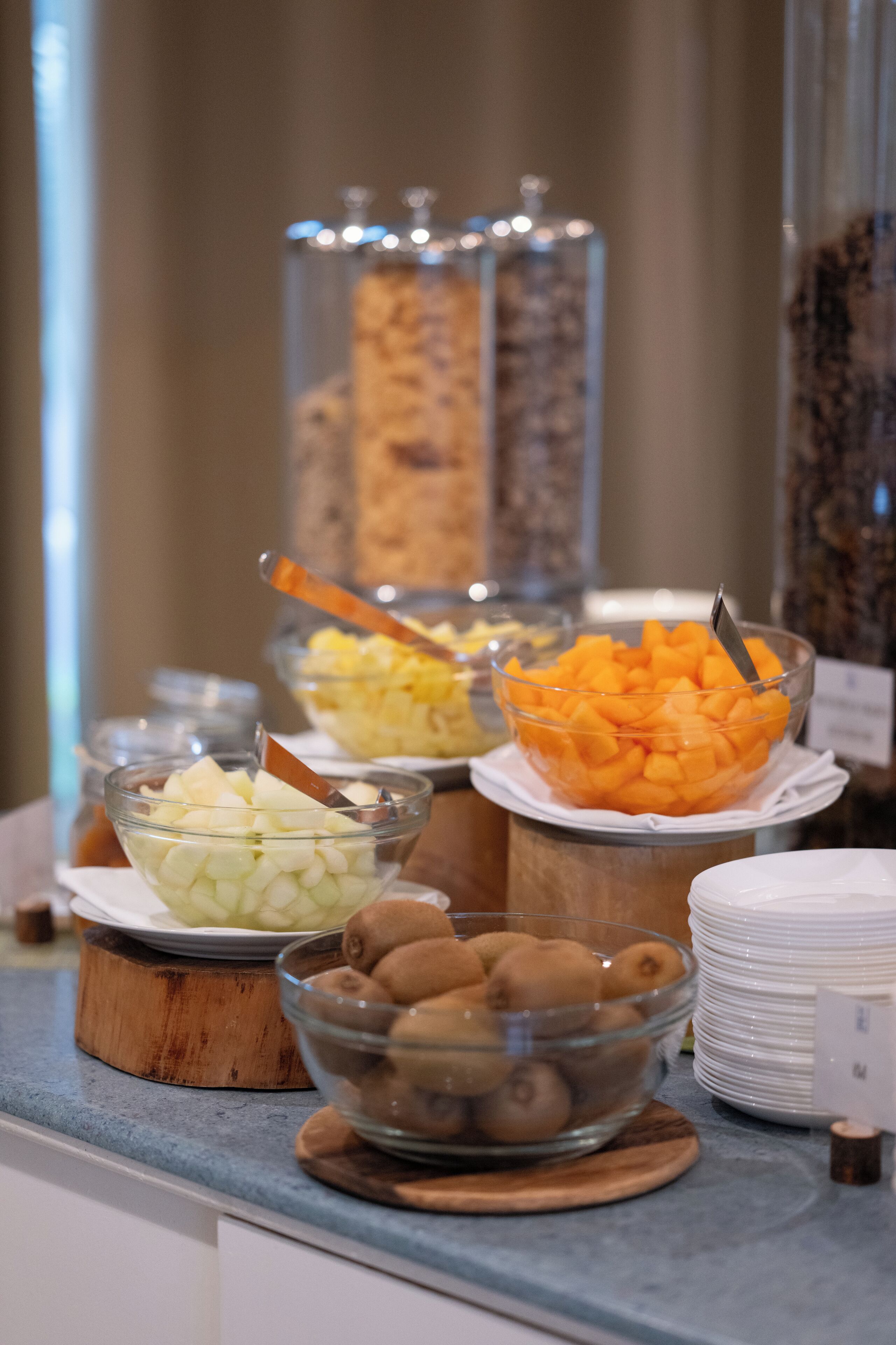 A buffet with various fruits and a coffee station.