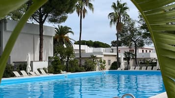 Relax by the pool surrounded by lush greenery and lounge in style.