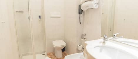 Un baño con ducha, inodoro, bidé y lavabo.